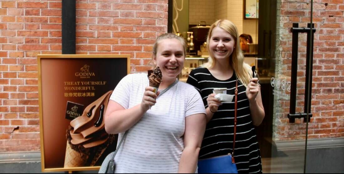 Two students smiling with dessert in Shanghai