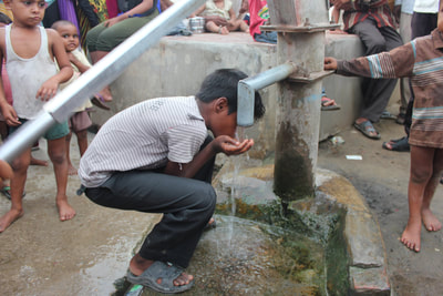 Boy drinking water from a pipe