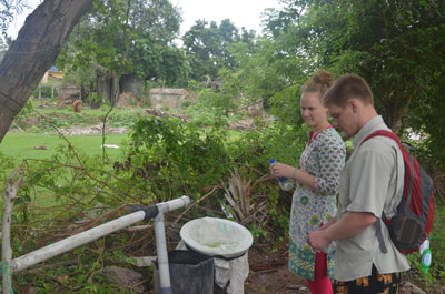 Members of the water team examine a local village's water collection mechanism.